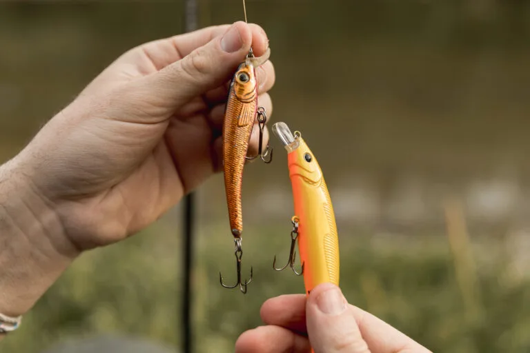 Person holding a realistic, vintage fishing lure from teh 1900s